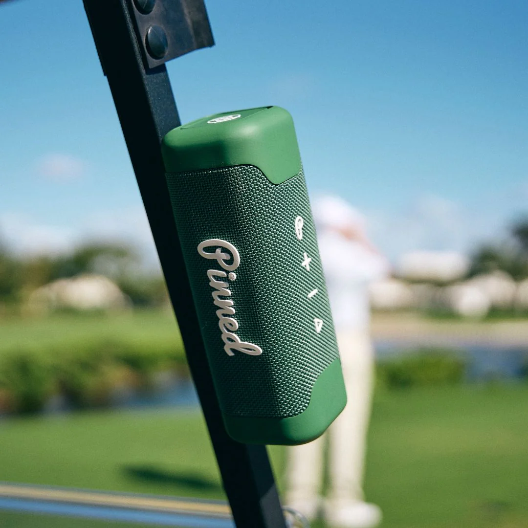 green pinned golf speaker on a golf cart with golfer in background