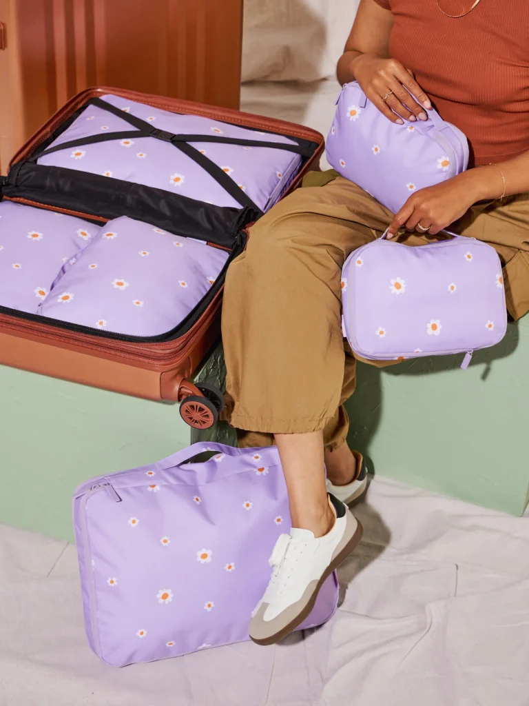 A traveler using CALPAK's compression cubes, in various sizes, to pack more and stay organized