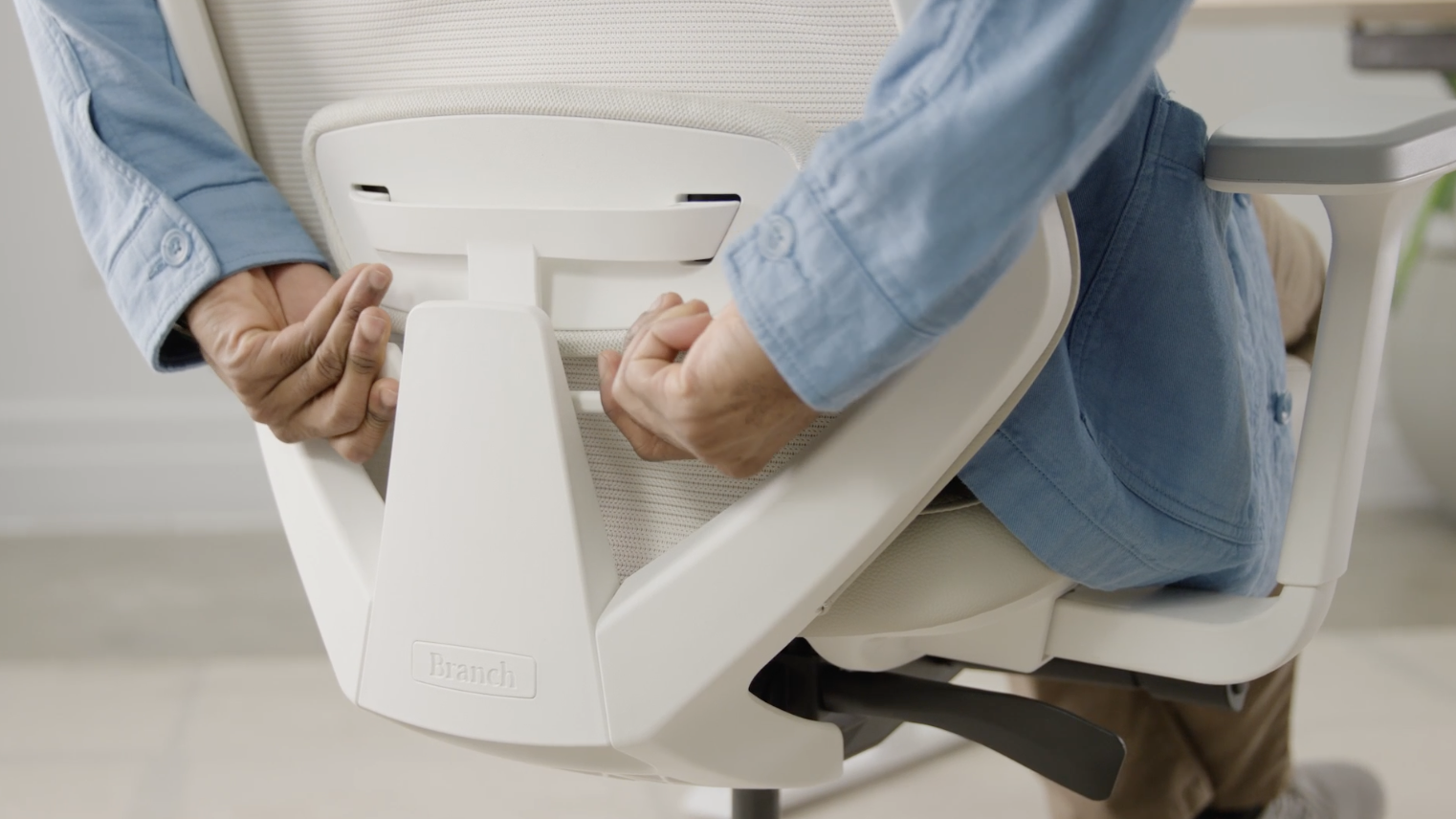 Person adjusting the backrest of a Branch Ergonomic Chair Pro