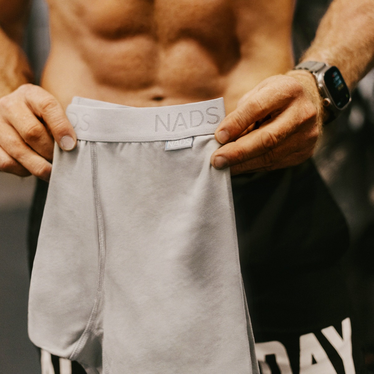 Person holding a pair of gray NADS branded underwear