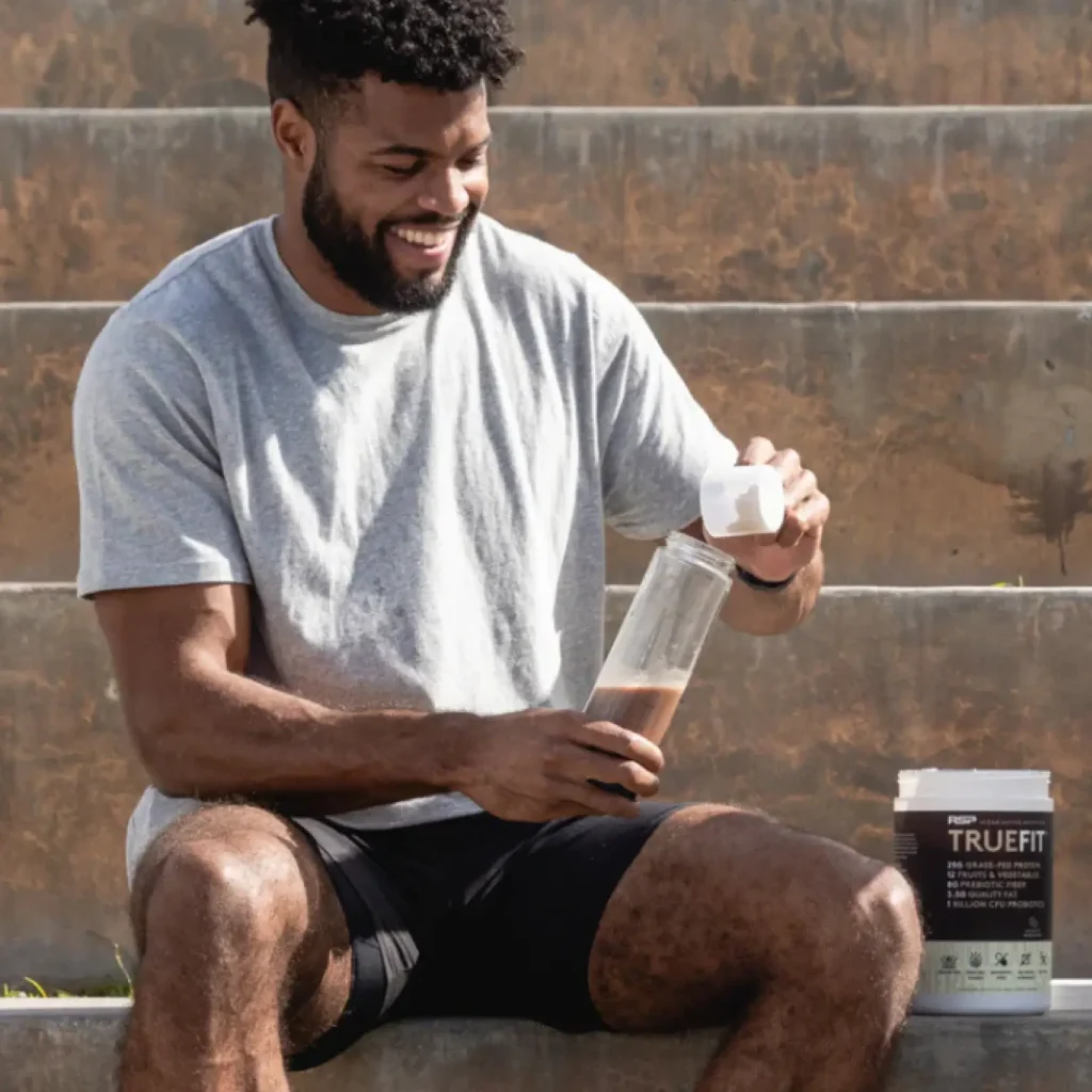 man pouring truefit into a waterbottle
