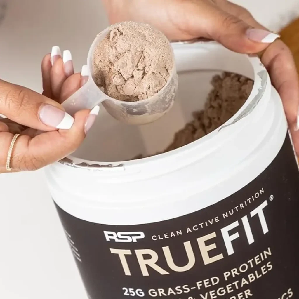 hand scooping truefit powder out of packaging